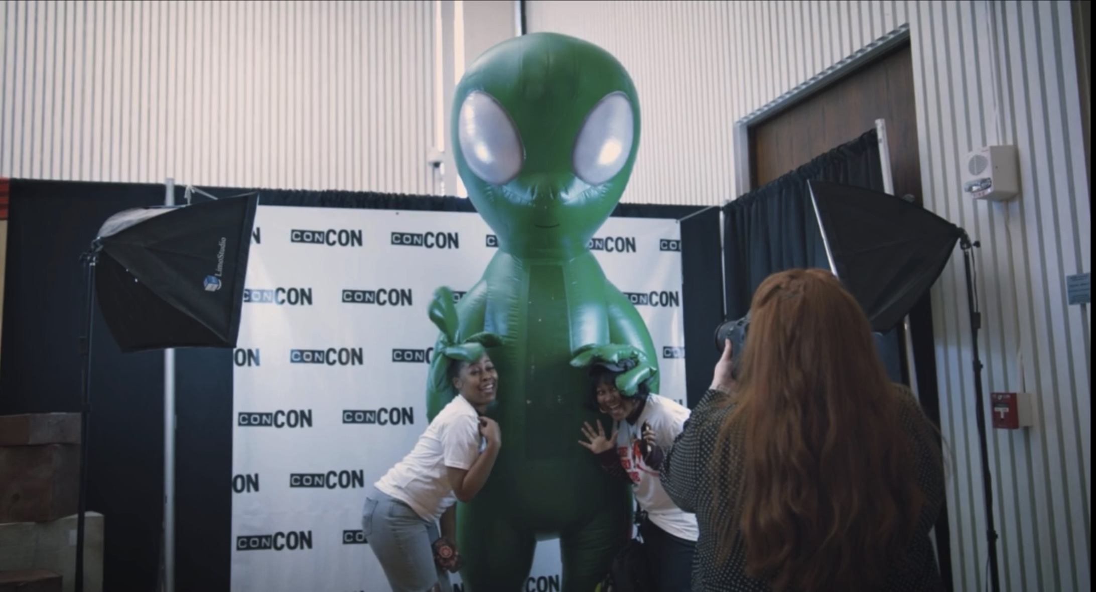 ConCon photo op with Green Guy alien and woman